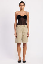 Emory Park model wearing a black sheer mesh floral cami top with spaghetti straps paired with khaki bermuda shorts and flats