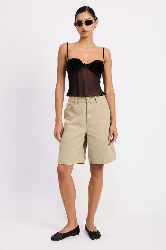 Emory Park model wearing a black sheer mesh floral cami top with delicate straps paired with khaki bermuda shorts