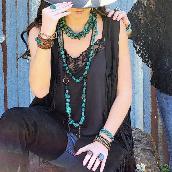 Black African turquoise bead bracelet worn with layered necklaces for a stylish boho look