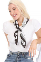 Stylish woman modeling a black and white silk scarf tied around her neck for an elegant look