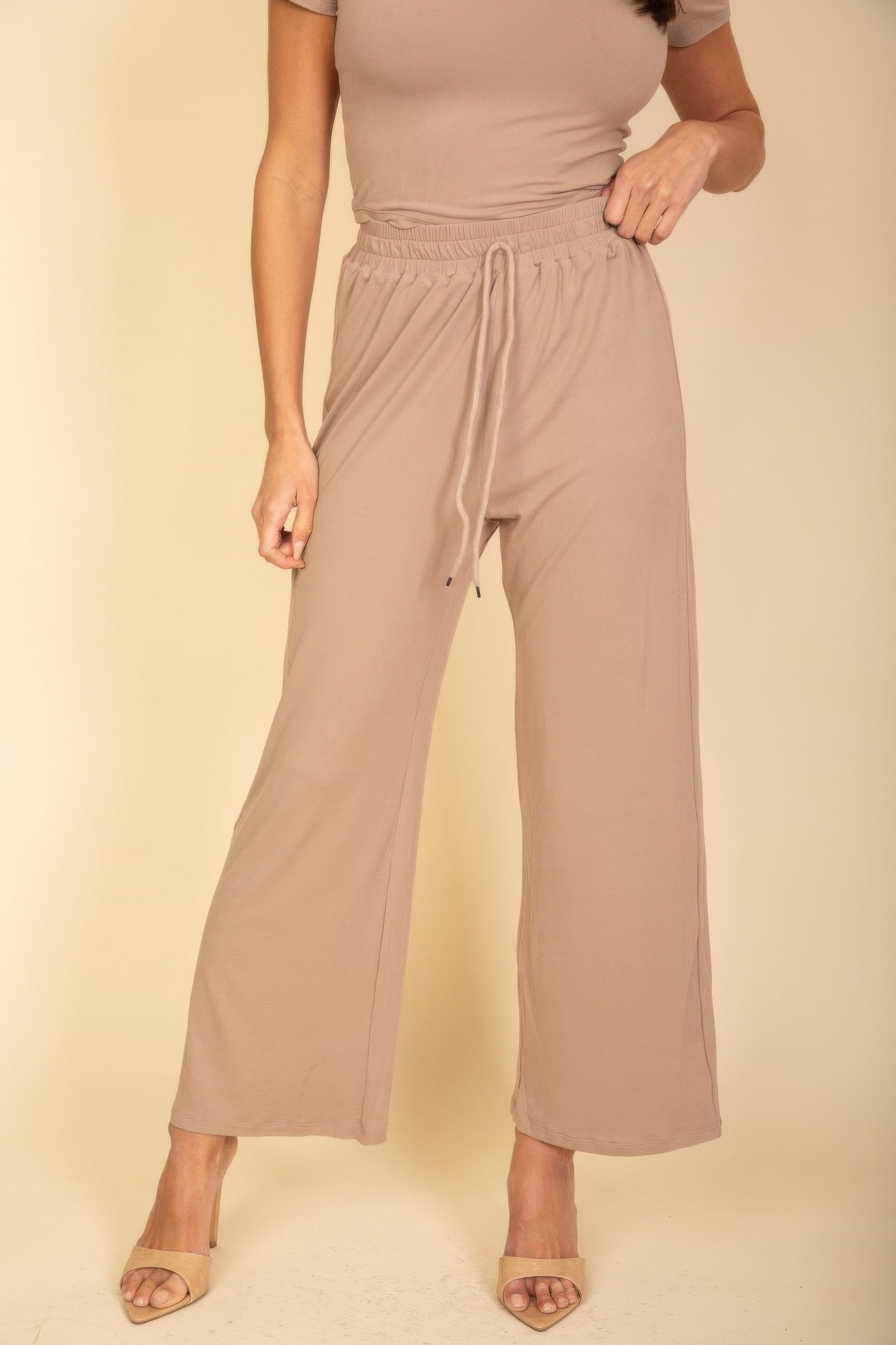 Women's beige wide-leg pants with drawstring waist in black casual travel outfit by VacationGrabs