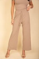 Women's beige wide-leg pants with drawstring waist in black casual travel outfit by VacationGrabs