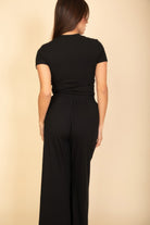 Woman wearing a black casual travel outfit with short sleeves and wide-leg pants from VacationGrabs
