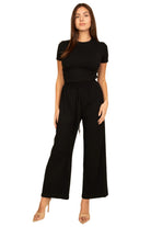 Woman wearing black casual travel outfit with short sleeve top and wide leg pants