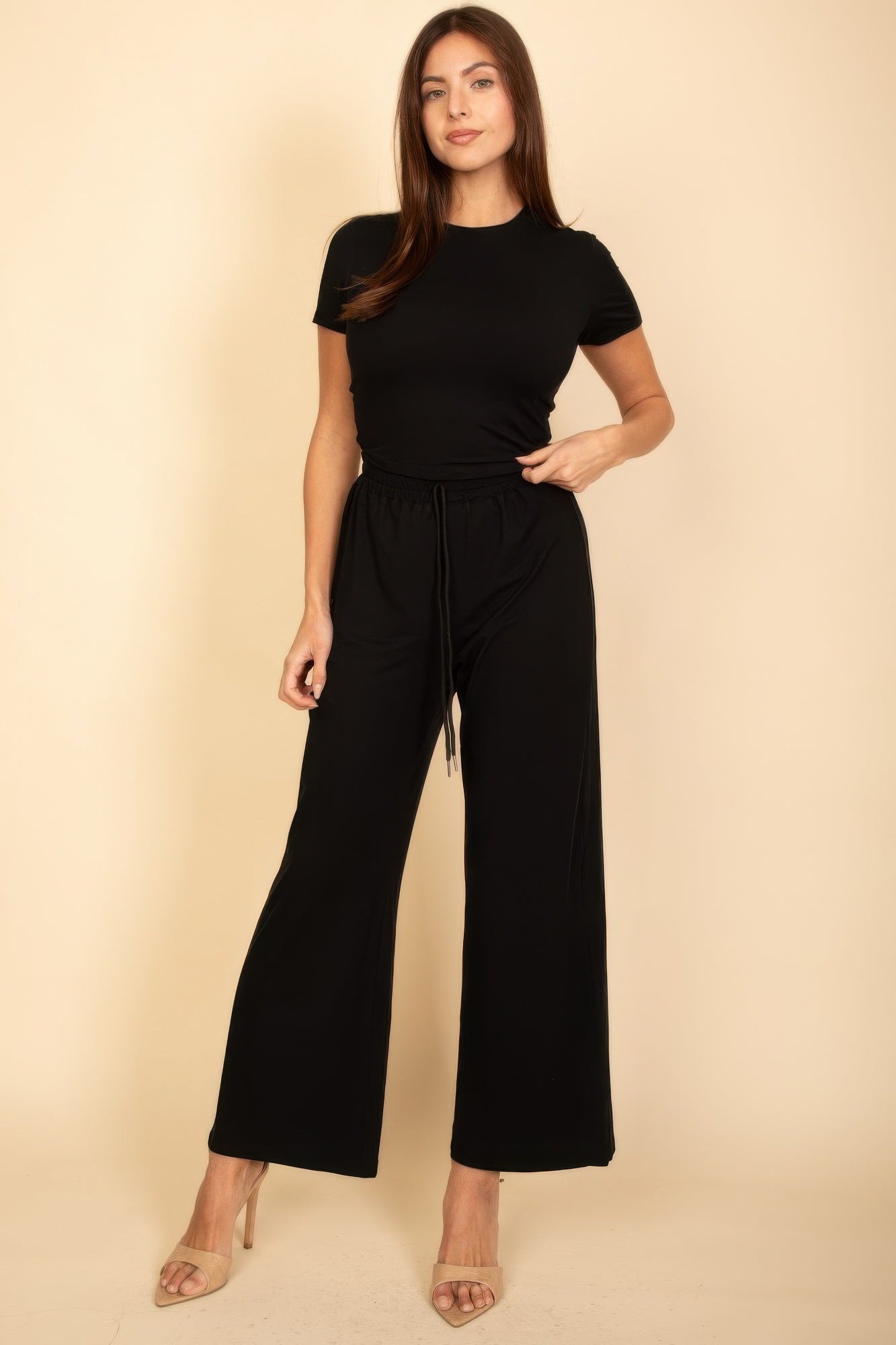 Woman wearing a black casual travel outfit with short sleeve top and wide leg pants
