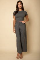 Woman wearing black casual travel outfit with short sleeve top and wide-leg pants by VacationGrabs