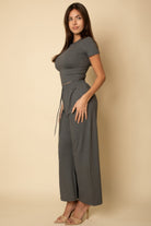 Woman wearing black casual travel outfit with fitted top and wide-leg pants by VacationGrabs