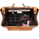 Interior view of black coffee leather duffel showing organized compartments and accessories