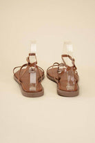 Back view of Top Guy Footwear brown sandals featuring black flat strappy sandals design