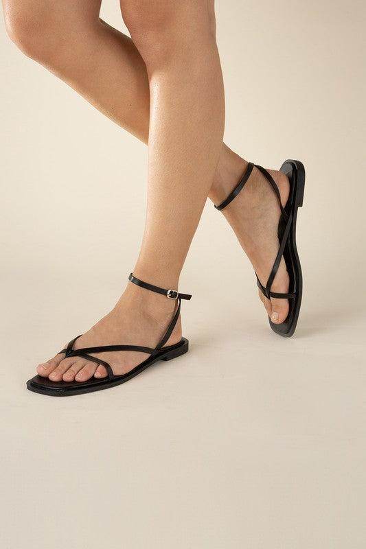 Women wearing black flat strappy sandals from Top Guy Footwear with a stylish and comfortable design