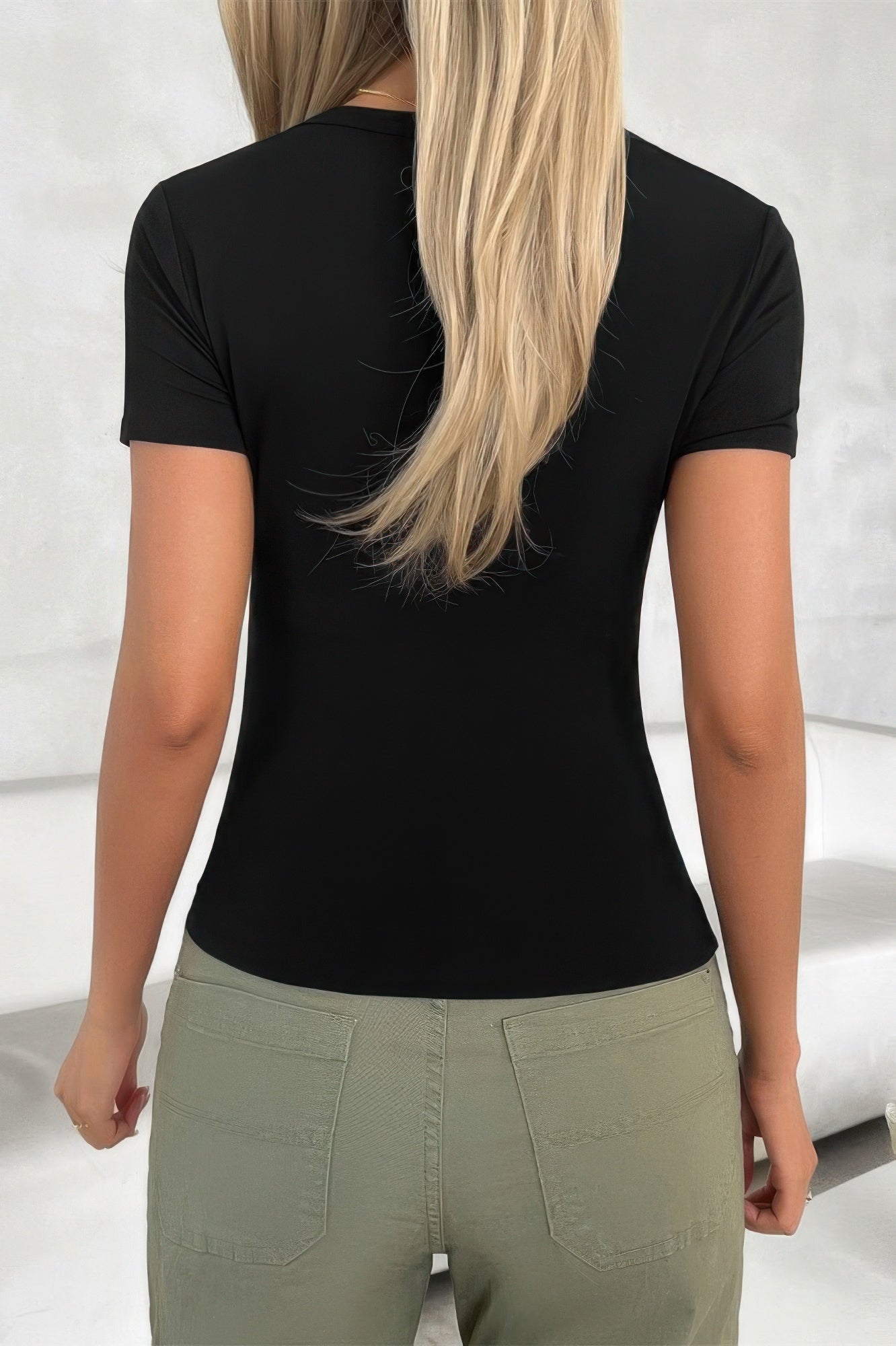 Back view of a women's black scoop neck top for women paired with casual pants