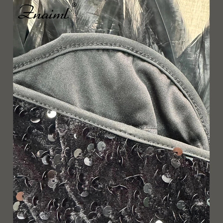 Close-up of black sequin feather mini dress fabric with shiny sequins and soft lining