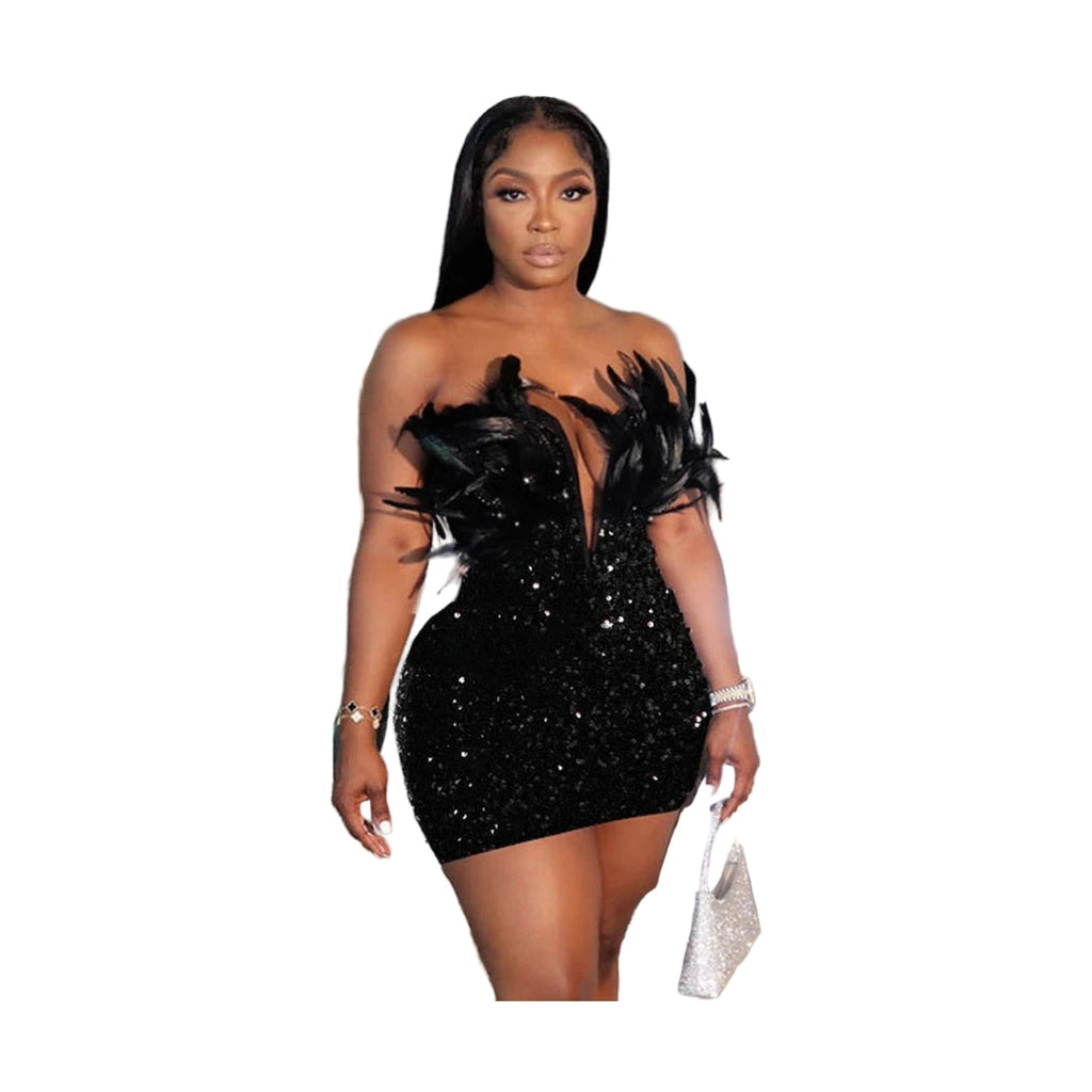 Woman wearing a black sequin feather mini dress standing in front of an ornate mirror holding a silver handbag