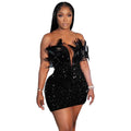 Woman wearing a black sequin feather mini dress with off-shoulder design and deep neckline