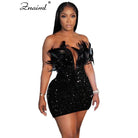 Woman wearing a black sequin feather mini dress with off-shoulder design and deep neckline
