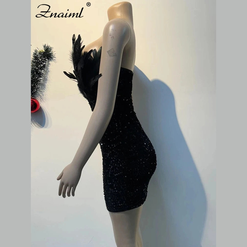 Black sequin feather mini dress on mannequin with strapless design and textured detailing