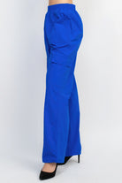 Women's blue high-rise cargo parachute pants with elastic waistband and side pockets