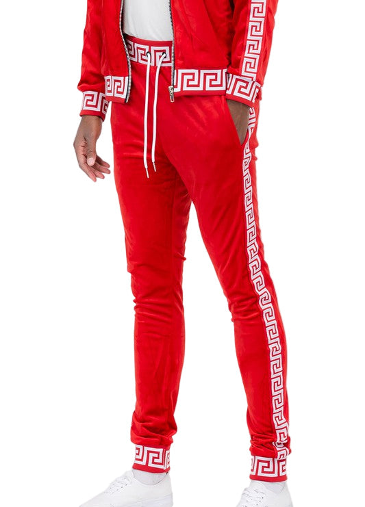 Red velour jogger pants with white geometric pattern from WEIV styled with white sneakers