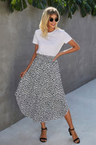 Woman wearing a VacationGrabs boho print flowy skirt paired with a white t-shirt and black sandals