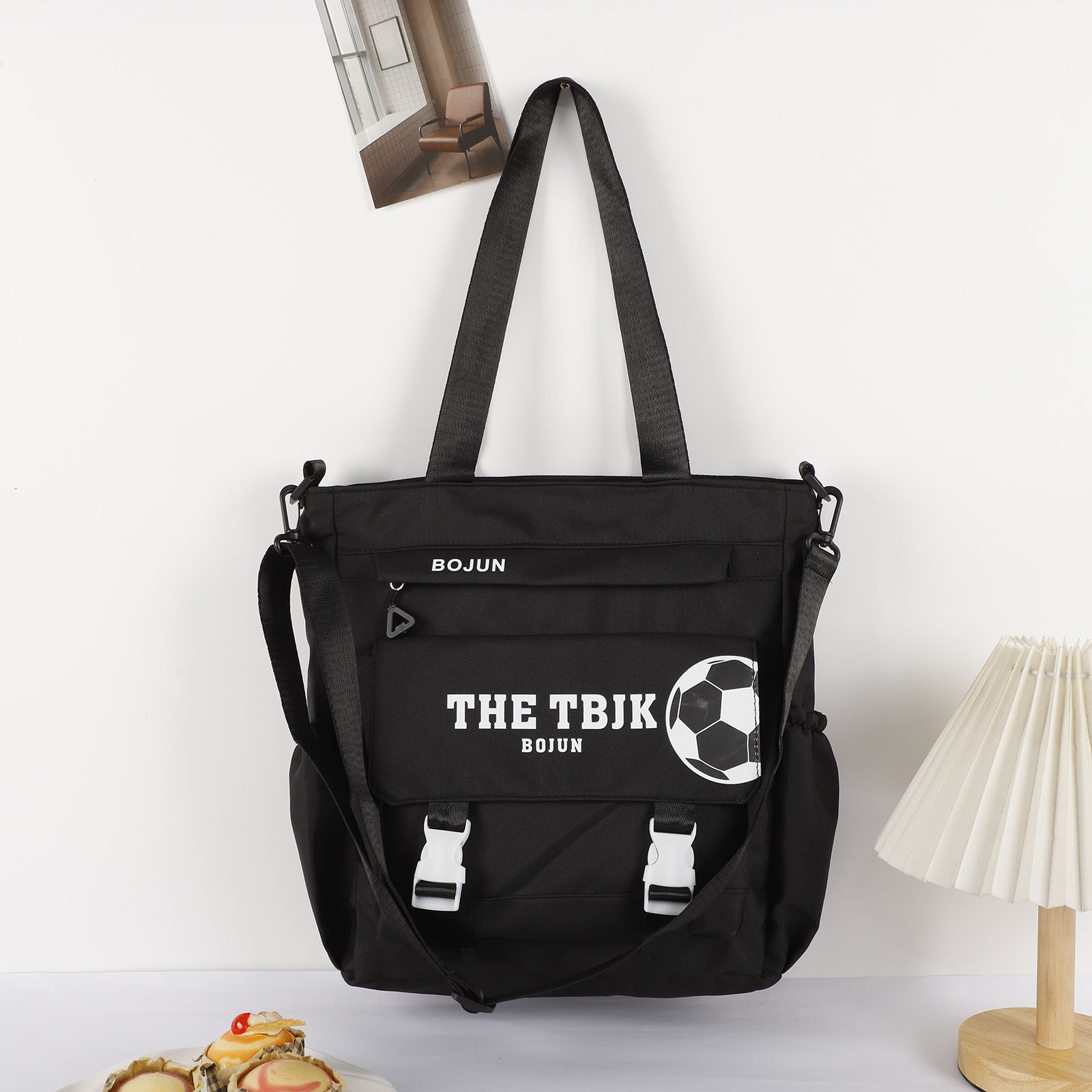 Black large capacity tote bag with soccer design and adjustable straps for everyday use