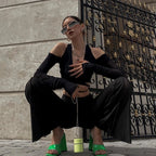 Woman wearing sheer streetwear crop tee for women in black paired with wide-leg pants and green heels