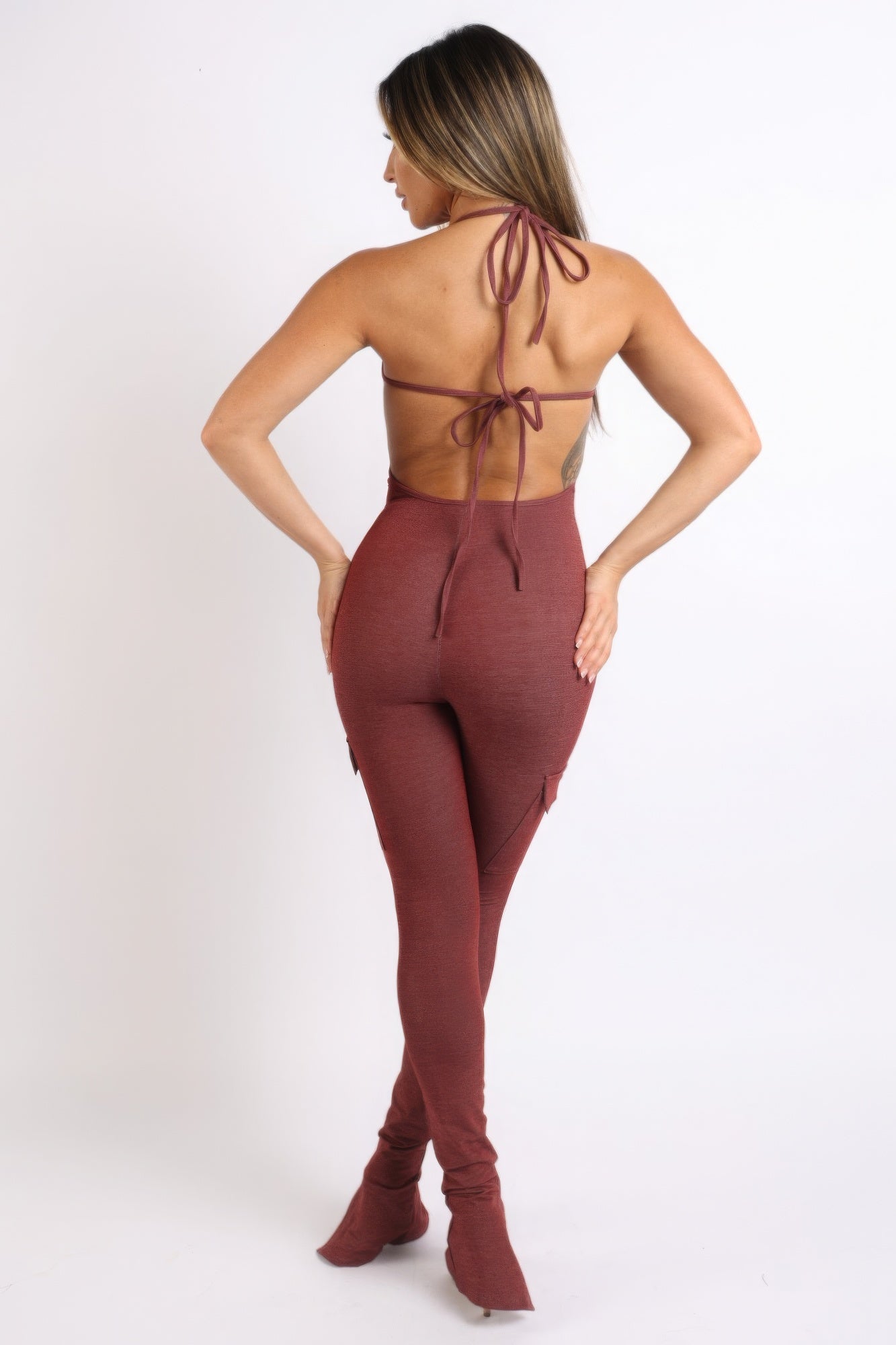 Back view of a burgundy cargo pocket halter jumpsuit with stylish ties and a fitted design