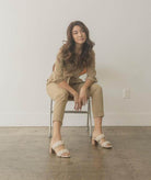 Oasis Society casual braided heel sandals in a stylish setting with a model seated on a chair