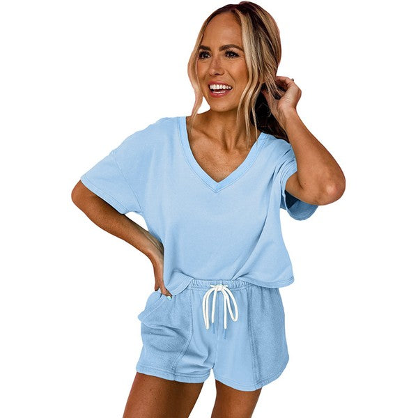 Woman wearing light blue casual drawstring shorts set with V-neck top and adjustable waist tie