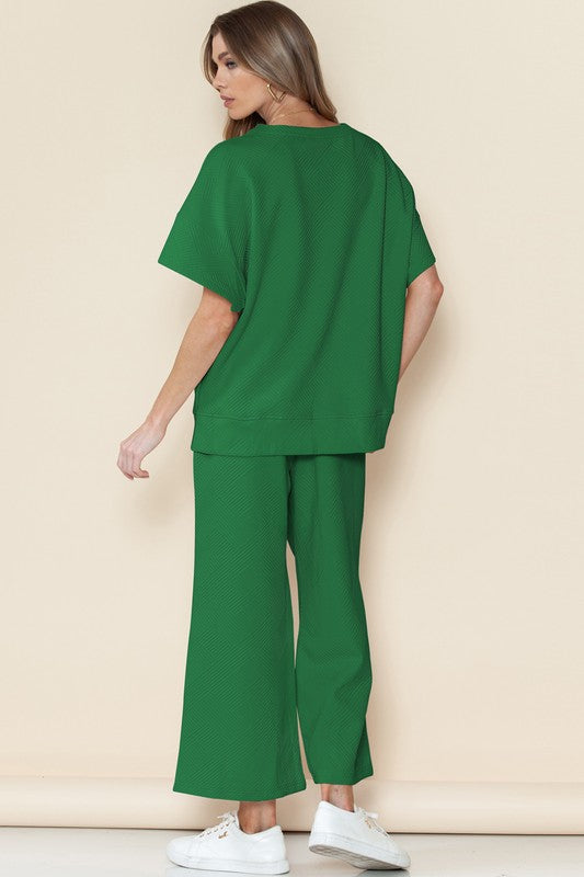 Woman wearing green casual matching sets for travel with loose top and wide-leg pants