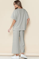 Woman wearing light gray casual matching sets for travel with loose top and wide-leg pants