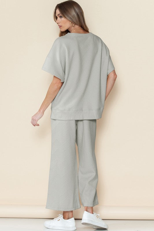 Woman wearing light gray casual matching sets for travel with loose top and wide-leg pants