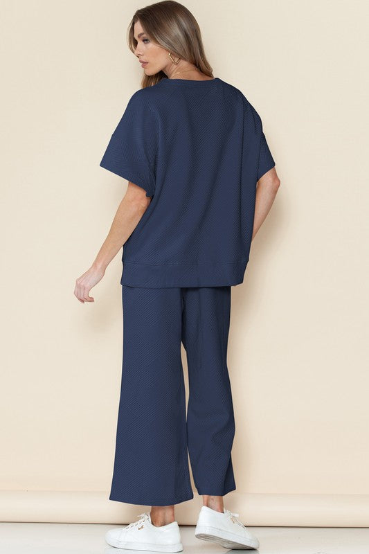 Woman wearing navy casual matching sets for travel with wide-leg pants and a loose top from SHEWIN INC