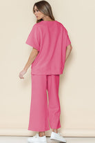 Woman wearing pink casual matching sets for travel with wide-leg pants and oversized top