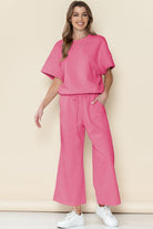Pink casual matching sets for travel with short sleeve top and wide-leg pants worn with white sneakers