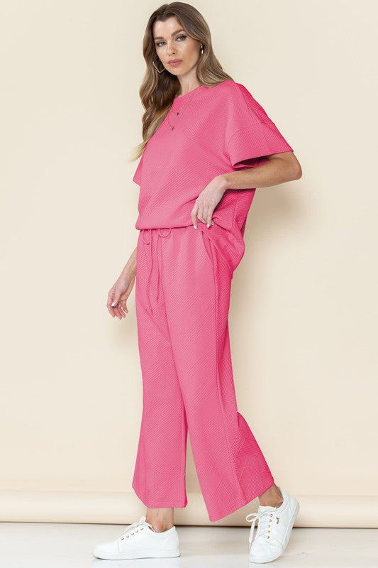 Pink casual matching sets for travel with loose short sleeve top and wide leg pants paired with white sneakers