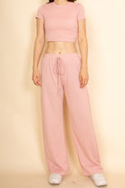 Casual wide-leg pants outfit by Capella in soft pink with a drawstring waist and paired with a fitted crop top
