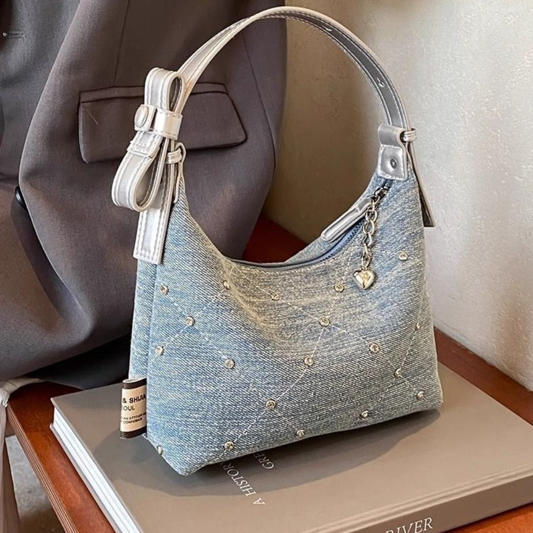 Chic denim hobo bag with silver accents and decorative heart charm for stylish casual wear