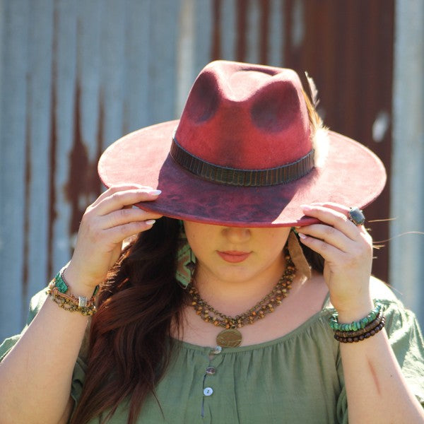 Woman wearing a chunky turquoise bracelet and a stylish hat for a trendy look