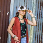 Model wearing a chunky turquoise bracelet alongside matching jewelry and a stylish outfit
