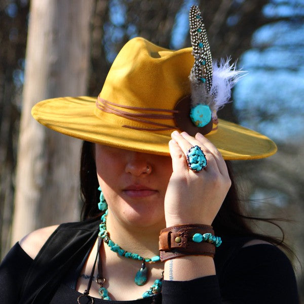 Woman wearing a chunky turquoise teardrop necklace with matching ring and bracelet for a stylish look