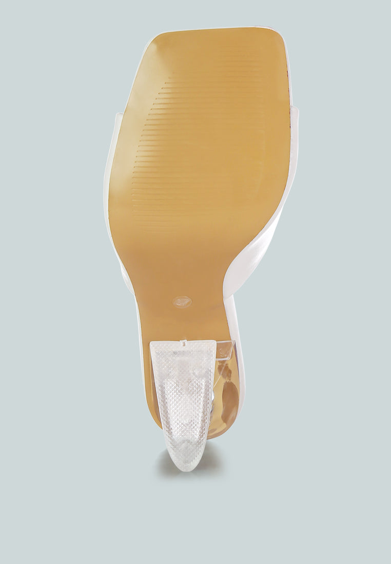 Underside view of clear spool heel sandals by London Rag International with transparent design