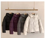 Women's puffer coat in black, purple, gray, and white for winter warmth
