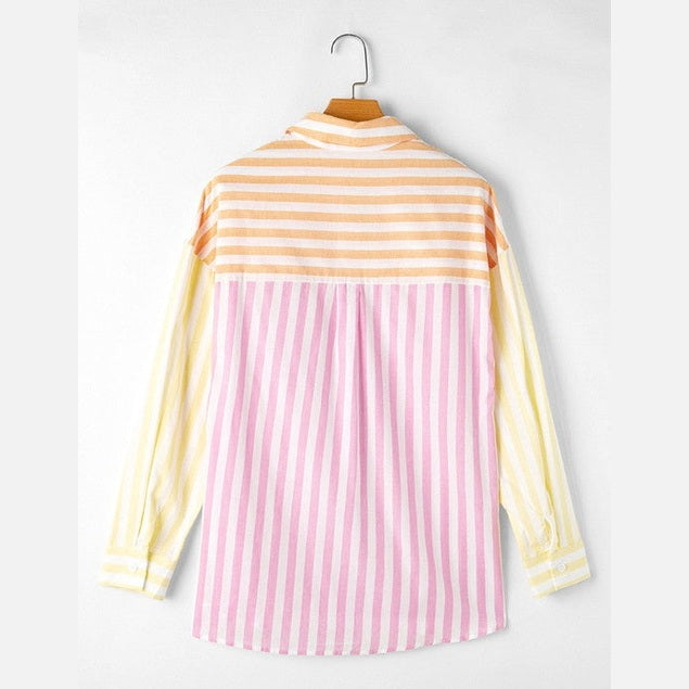 Back view of colorful patchwork shirt for women with orange, pink, and yellow stripes hanging on hanger