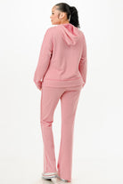 Back view of woman wearing comfortable pink hoodie and pants casual outfit set from VacationGrabs