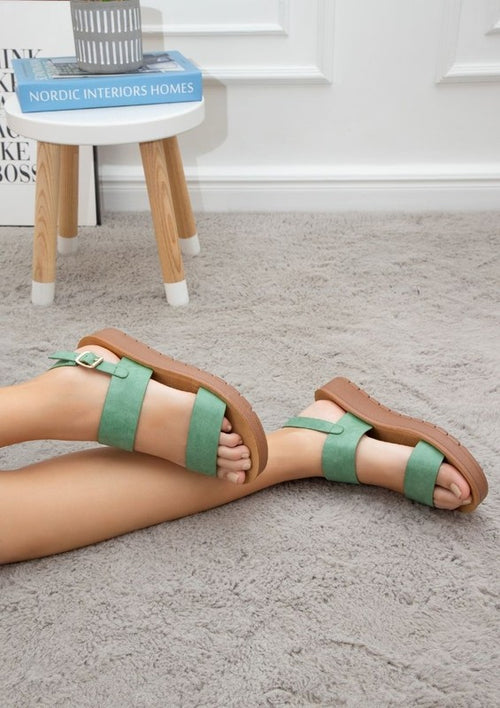 Comfortable summer sandals for women in green with brown soles by Maker's Shoes worn indoors