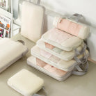 Vacuum-sealed compression packing cubes for travel in pastel colors