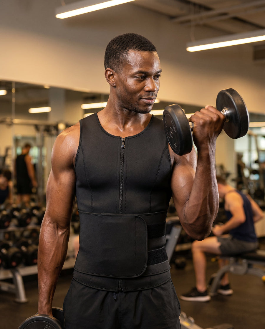 Man wearing black zip compression waist trainer performing dumbbell curl in gym