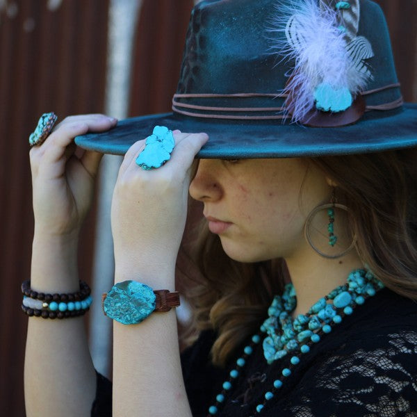 Beautiful copper hoop earrings with turquoise, paired with turquoise accessories and a stylish hat