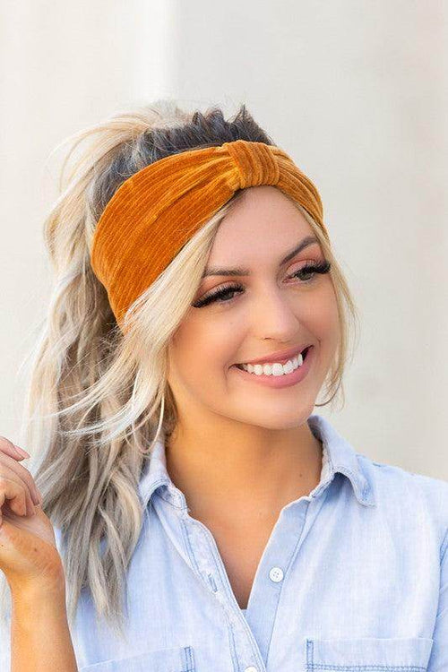 Aili's Corner corduroy hair wrap in rich orange color worn by a smiling woman with blonde hair