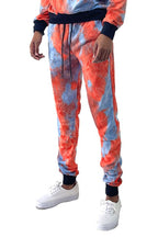 WEIV cotton tye dye sweatpants in orange and blue with black cuffs modeled with white sneakers